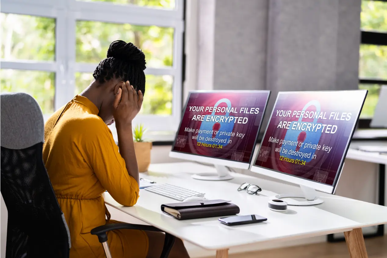 person-with-two-computers | Spin.AI A person sitting at a desk with two computer screens