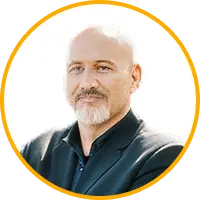 Professional headshot of a middle-aged man with a white beard wearing a dark blazer. Professional headshot of a middle-aged man with a white beard wearing a dark blazer.